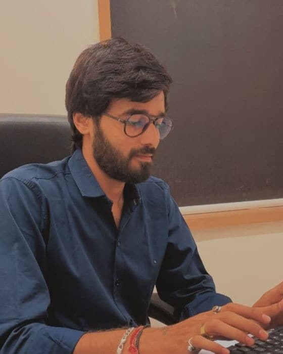 Tejas Parmar working at his desk at the Digital Confident office
