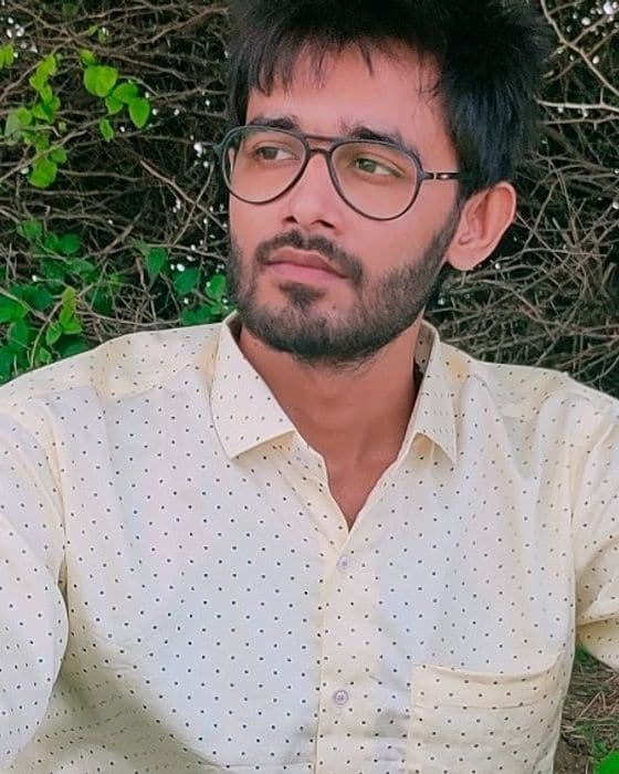 Tejas Parmar outdoors in a cream shirt and glasses